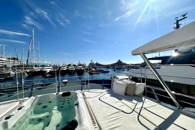 Slide: The Image of Luxurious 2023 Majesty 120 yacht with jacuzzi and sun deck, overlooking marina. - 7