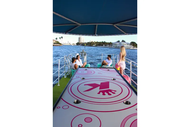 Slide: The Image of 2023 Maurell Pontoon with people relaxing on deck, scenic waterfront view. - 5