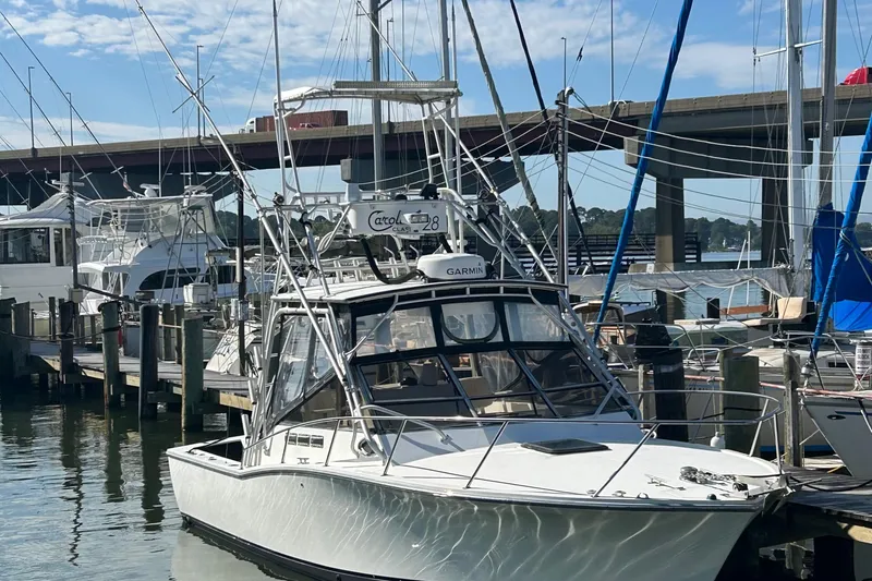 The Image of 1995 Carolina Classic 28 boat docked at marina under clear blue sky. - 0