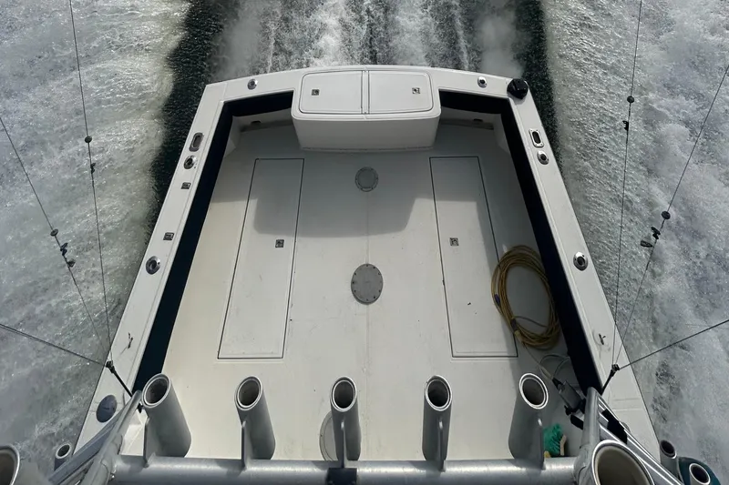 Slide: The Image of 1995 Carolina Classic 28 boat deck with fishing rod holders and ocean wake. - 4