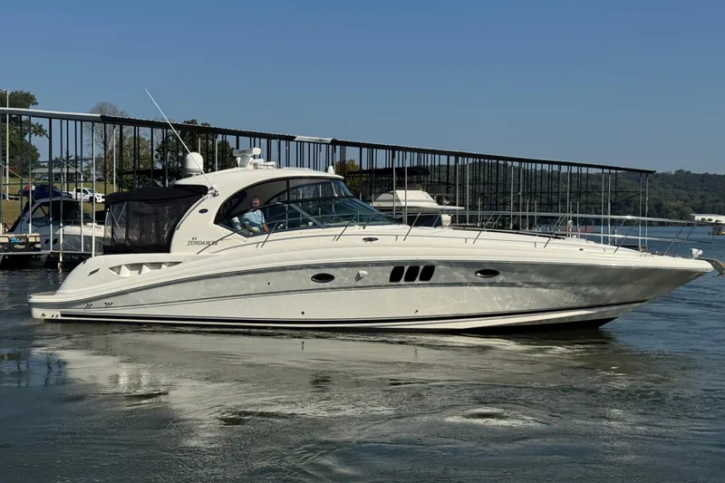 Slide: The Image of 2008 Sea Ray 44 Sundancer yacht docked on calm water under clear blue sky. - 3