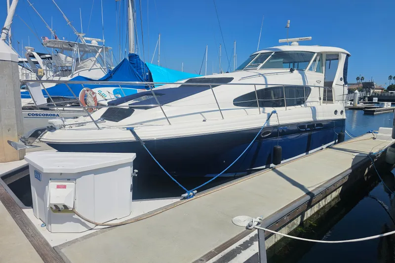 The Image of 2005 Sea Ray 390 Motor Yacht docked at marina under clear blue sky. - 0