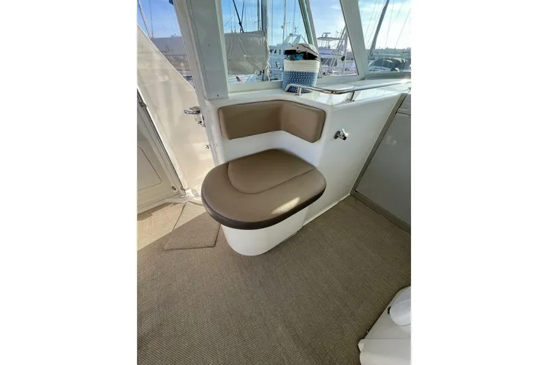 Slide: The Image of 2005 Sea Ray 390 Motor Yacht interior with cushioned seating and window view. - 17