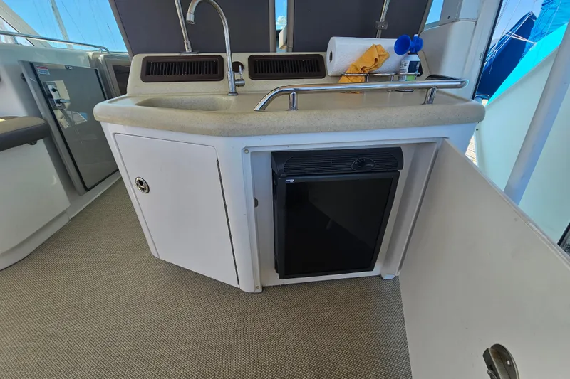 Slide: The Image of 2005 Sea Ray 390 Motor Yacht interior with sink, mini fridge, and storage cabinet. - 20