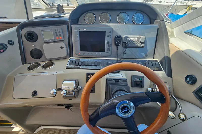Slide: The Image of 2005 Sea Ray 390 Motor Yacht helm with navigation instruments and wooden steering wheel. - 23