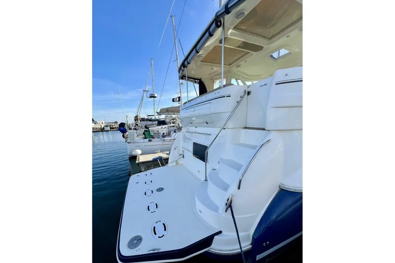 Slide: The Image of 2005 Sea Ray 390 Motor Yacht docked, showcasing rear deck and steps. - 9