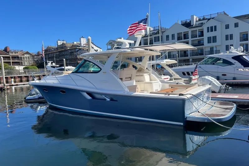 The Image of 2014 Tiara Yachts 3900 Coronet docked in a marina, featuring sleek design and American flag. - 0
