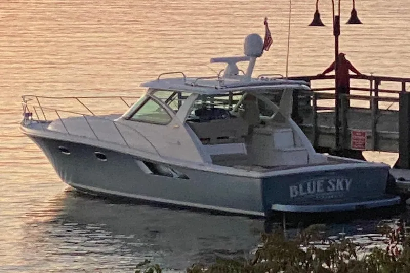 Slide: The Image of 2014 Tiara Yachts 3900 Coronet docked at sunset, named "Blue Sky." - 1