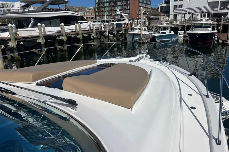 Slide: The Image of 2014 Tiara Yachts 3900 Coronet docked at marina, featuring spacious deck and sunpads. - 10