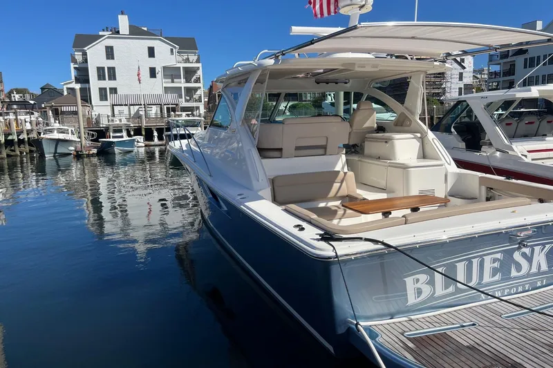 Slide: The Image of 2014 Tiara Yachts 3900 Coronet docked in a marina, featuring sleek design and spacious seating. - 12