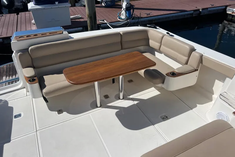 Slide: The Image of 2014 Tiara Yachts 3900 Coronet cockpit with beige seating and wooden table. - 17