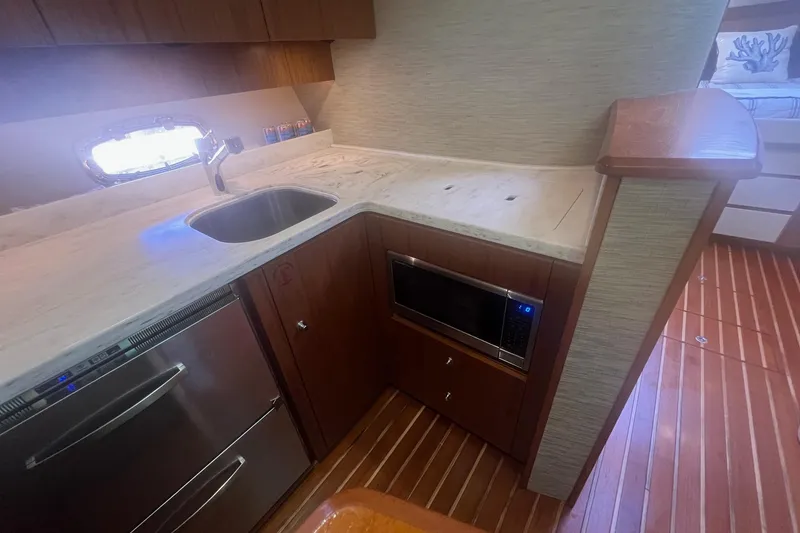 Slide: The Image of 2014 Tiara Yachts 3900 Coronet kitchen with sink, microwave, and wooden cabinetry. - 45