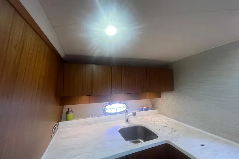 Slide: The Image of 2014 Tiara Yachts 3900 Coronet interior kitchen with wooden cabinets and marble countertop. - 46