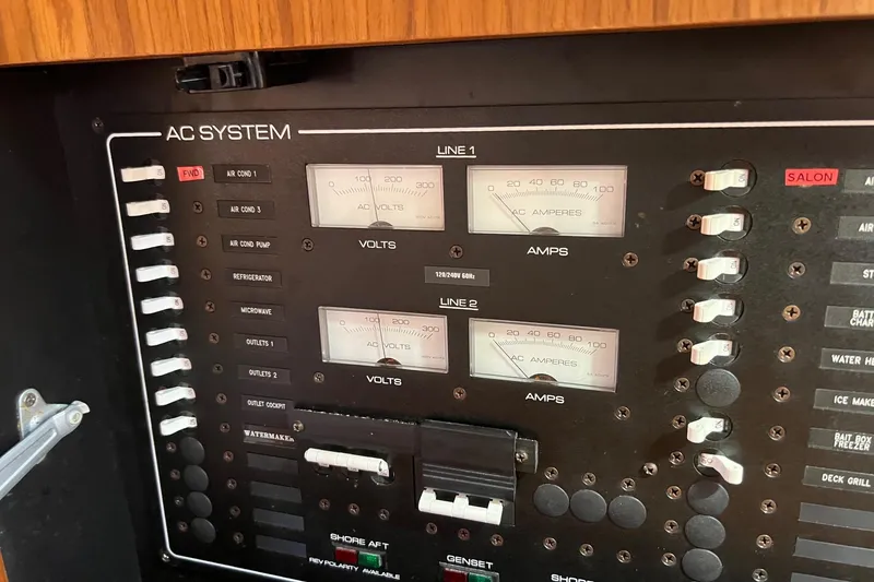 Slide: The Image of Control panel of a 2014 Tiara Yachts 3900 Coronet, featuring AC system gauges and switches. - 54