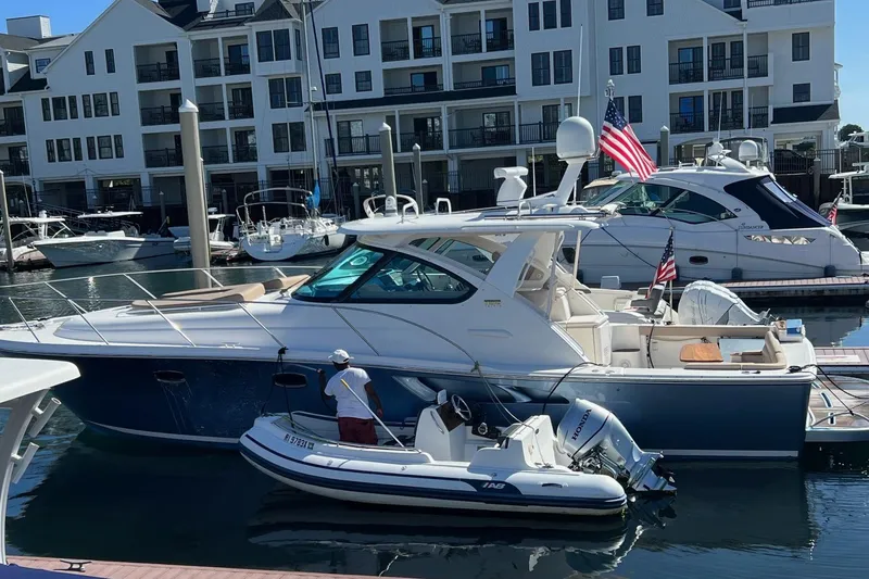 Slide: The Image of 2014 Tiara Yachts 3900 Coronet docked at marina with inflatable boat nearby. - 6