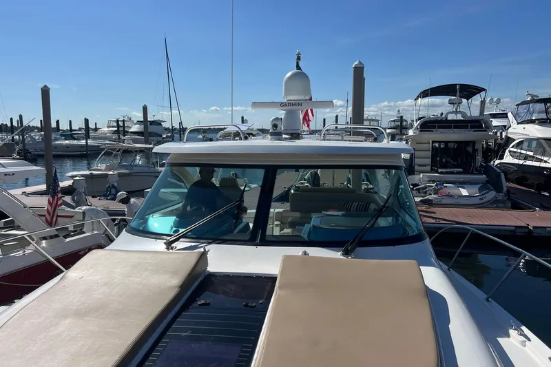 Slide: The Image of 2014 Tiara Yachts 3900 Coronet docked at marina, clear sky, multiple boats in background. - 9