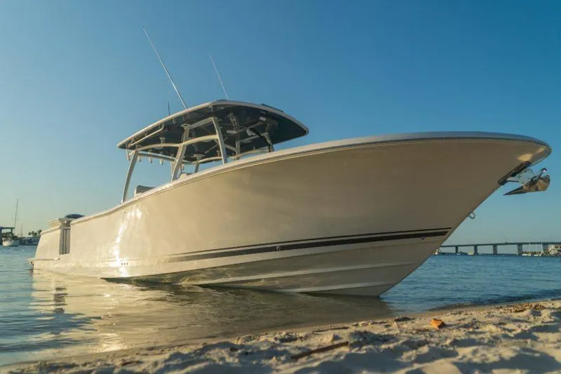 The Image of 2026 Southport 33 FE boat on sandy shore under clear blue sky. - 0