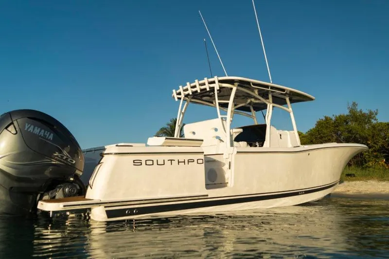 Slide: The Image of 2026 Southport 33 FE boat with Yamaha engine, docked in calm waters. - 2