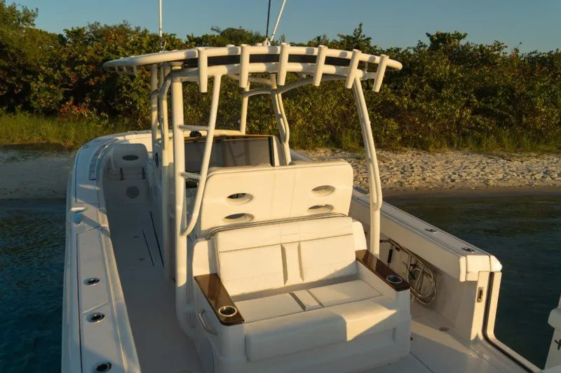 Slide: The Image of 2026 Southport 33 FE boat with seating, docked by sandy shore. - 3