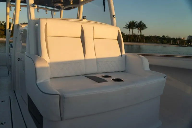 Slide: The Image of Luxurious seating on 2026 Southport 33 FE boat, featuring white upholstery and cup holders. - 6