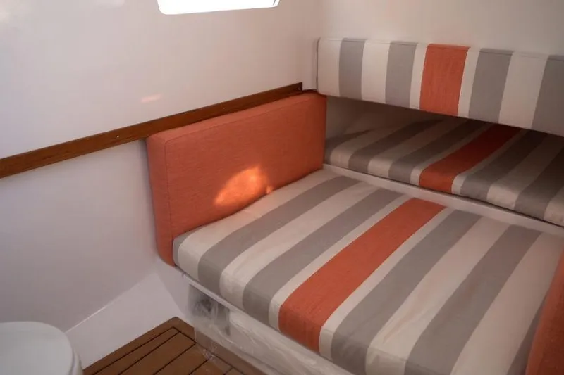 Slide: The Image of 2026 Southport 33 FE cabin with striped orange and gray cushions. - 8