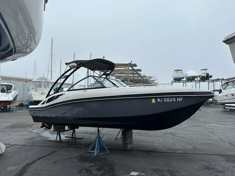 Slide: The Image of 2014 Starcraft Crossover 210 SCX IO boat on stands in a marina. - 8