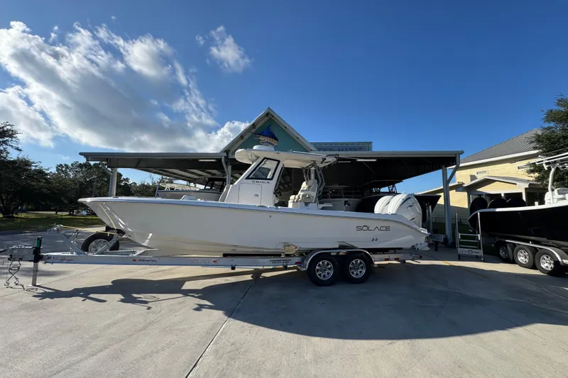 The Image of 2026 Solace 28 HCS boat on trailer under clear blue sky. - 1