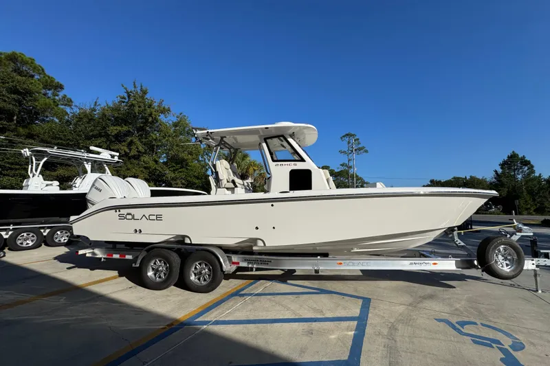 Slide: The Image of 2026 Solace 28 HCS boat on trailer, parked outdoors under clear blue sky. - 10