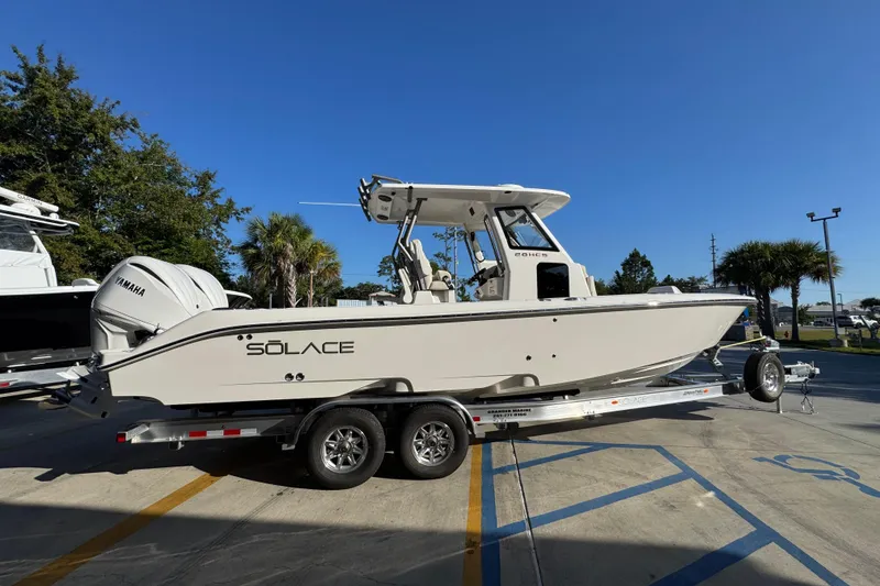 Slide: The Image of 2026 Solace 28 HCS boat on trailer, featuring Yamaha engine, parked outdoors. - 11