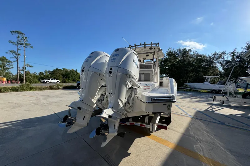 Slide: The Image of 2026 Solace 28 HCS boat with dual outboard engines, parked outdoors under clear blue sky. - 14