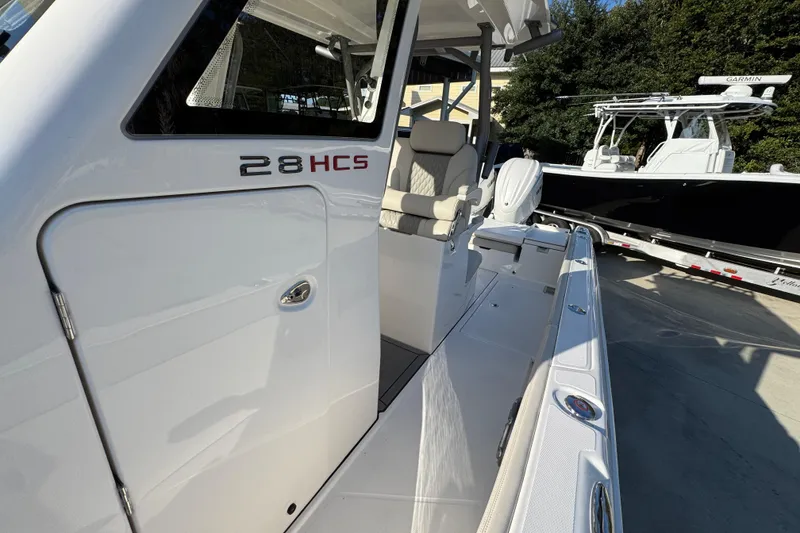 Slide: The Image of 2026 Solace 28 HCS boat, white exterior, sleek design, docked outdoors. - 26
