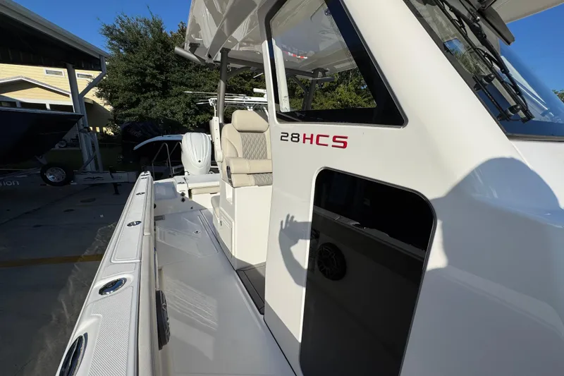 Slide: The Image of 2026 Solace 28 HCS boat, white exterior, docked with visible seating and equipment. - 27