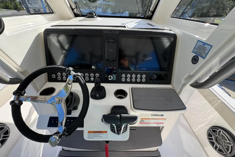Slide: The Image of Helm of 2026 Solace 28 HCS boat with steering wheel and dual screens. - 35
