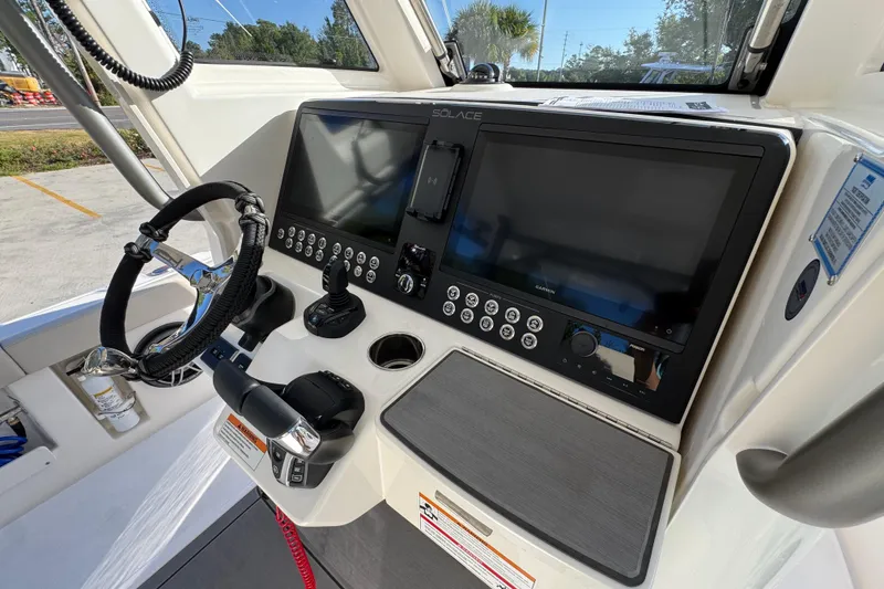 Slide: The Image of 2026 Solace 28 HCS boat dashboard with dual screens and modern controls. - 37