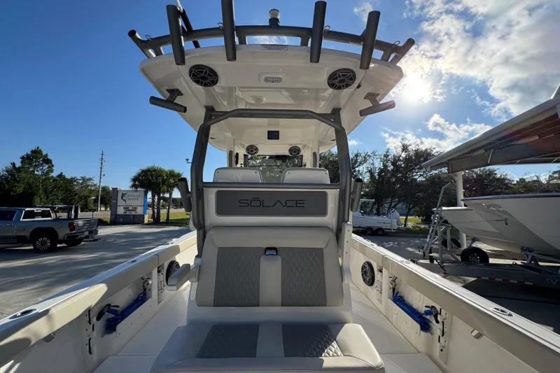 Slide: The Image of 2026 Solace 28 HCS boat interior with seating and rod holders under a clear sky. - 44