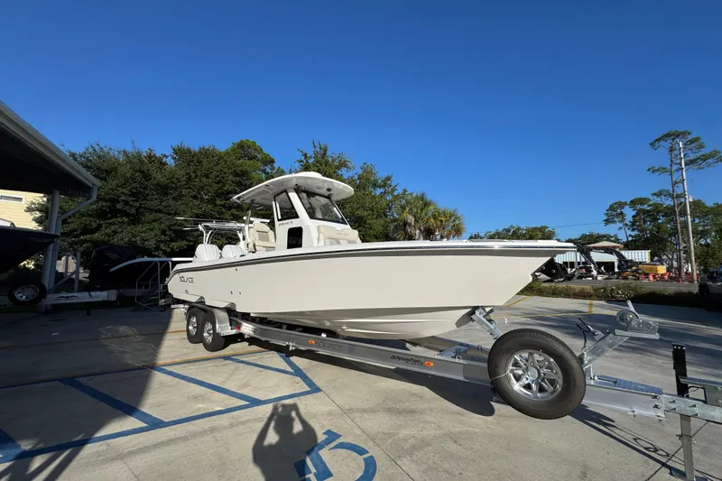 Slide: The Image of 2026 Solace 28 HCS boat on trailer, parked outdoors under clear blue sky. - 8
