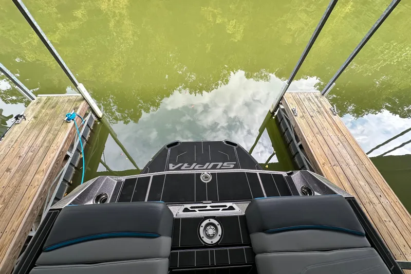 Slide: The Image of 2024 Supra SV 400 boat cruising on a lake with lush green shoreline. - 10