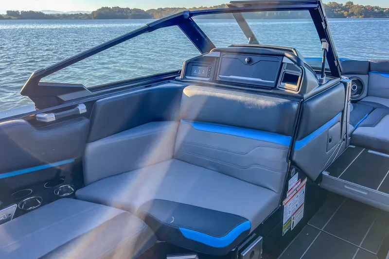 Slide: The Image of 2024 Supra SV 400 boat interior with sleek seating and modern design on a serene lake. - 23