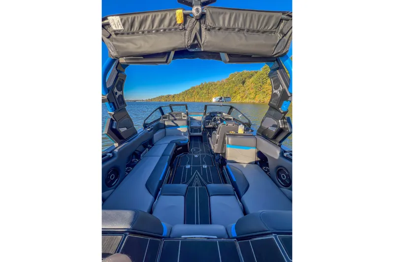 Slide: The Image of 2024 Supra SV 400 boat interior with sleek seating and modern design on a scenic lake. - 27