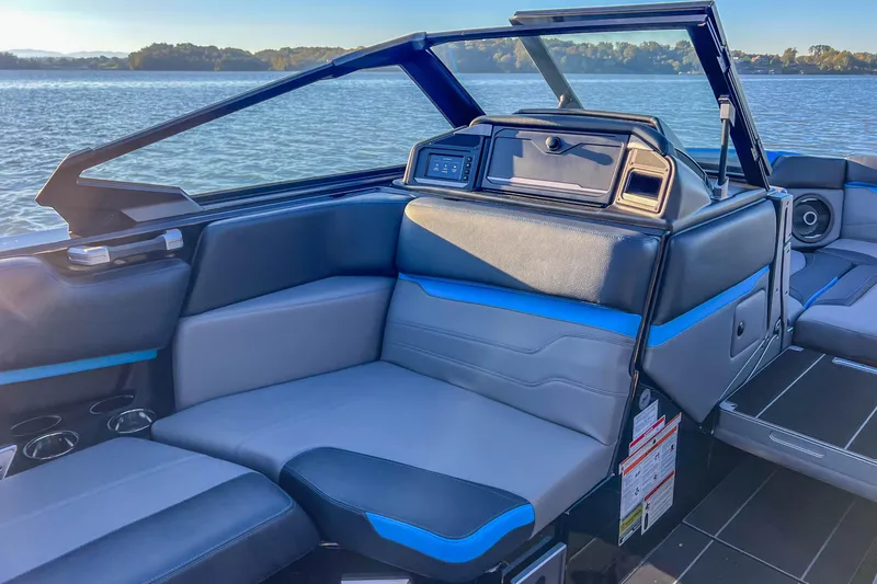Slide: The Image of 2024 Supra SV 400 boat interior with luxurious seating and modern dashboard on a serene lake. - 32