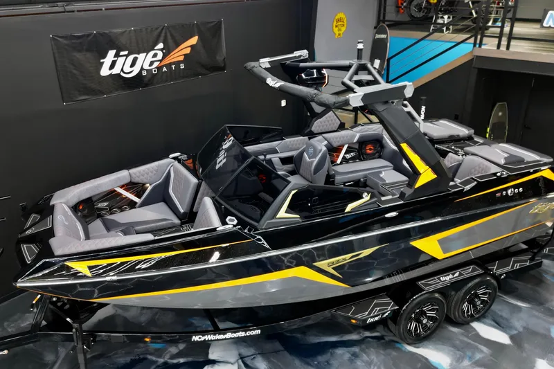 Slide: The Image of 2026 Tigé 22RZX boat with sleek black and yellow design in showroom. - 10