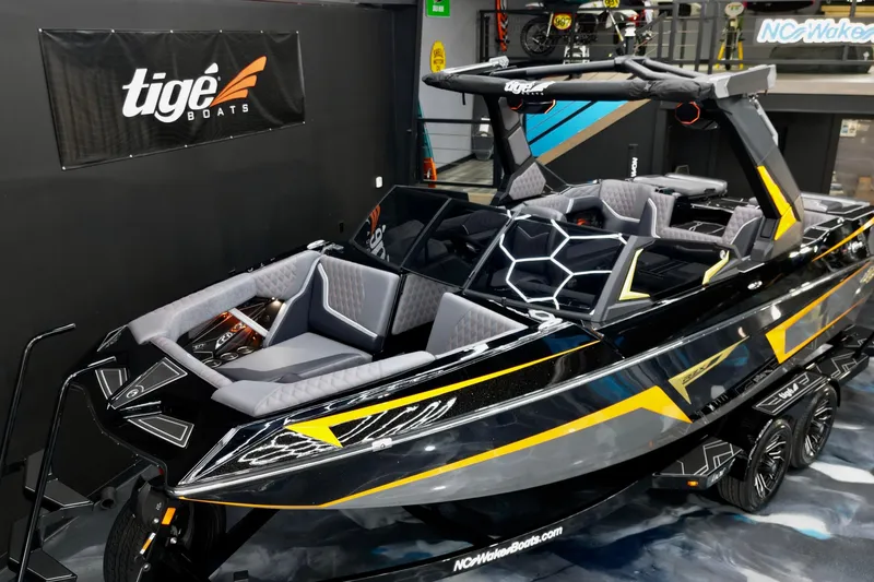 Slide: The Image of 2026 Tigé 22RZX boat with sleek black and yellow design, showcased indoors. - 9