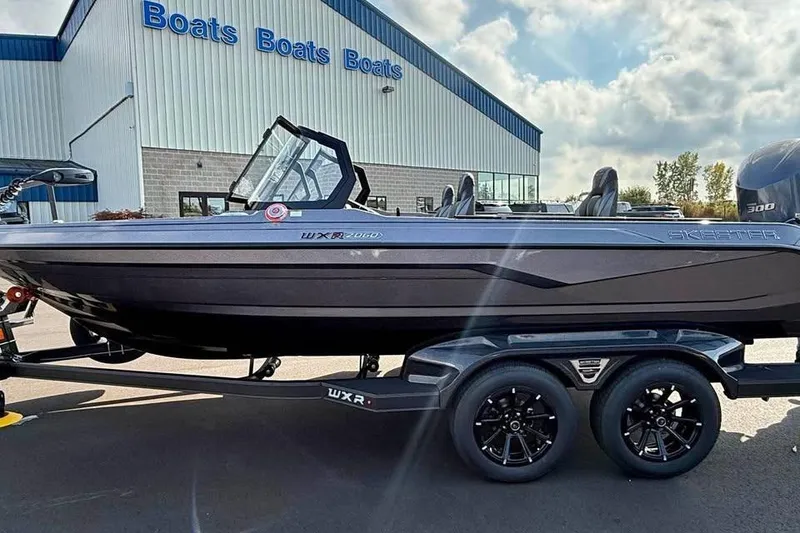 Slide: The Image of 2026 Skeeter WXR2060 boat on trailer outside dealership under cloudy sky. - 5