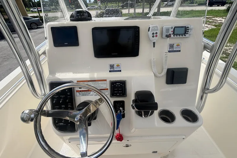 Slide: The Image of 2022 Cobia 237 Center Console boat dashboard with steering wheel and navigation equipment. - 14