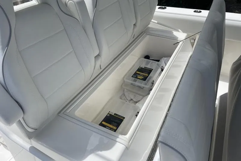 Slide: The Image of 2022 SeaVee 370z boat storage compartment with white cushioned seats and organized storage boxes. - 14