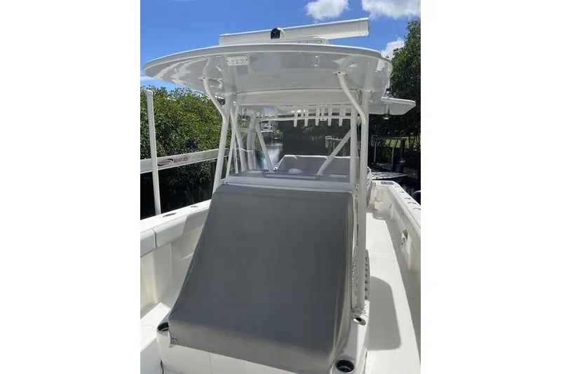 Slide: The Image of 2022 SeaVee 370z boat with T-top and console, docked near lush greenery. - 24