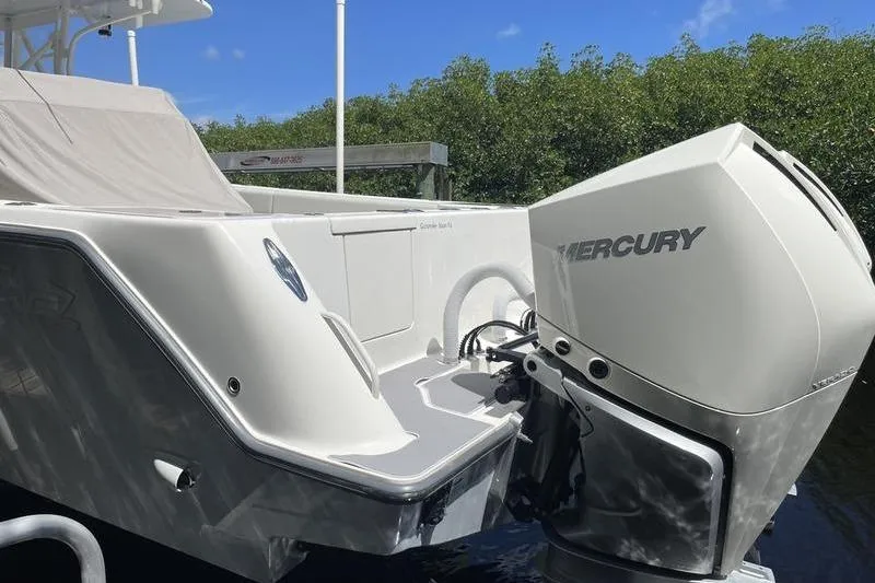 Slide: The Image of 2022 SeaVee 370z boat with Mercury engine, docked near lush greenery. - 44