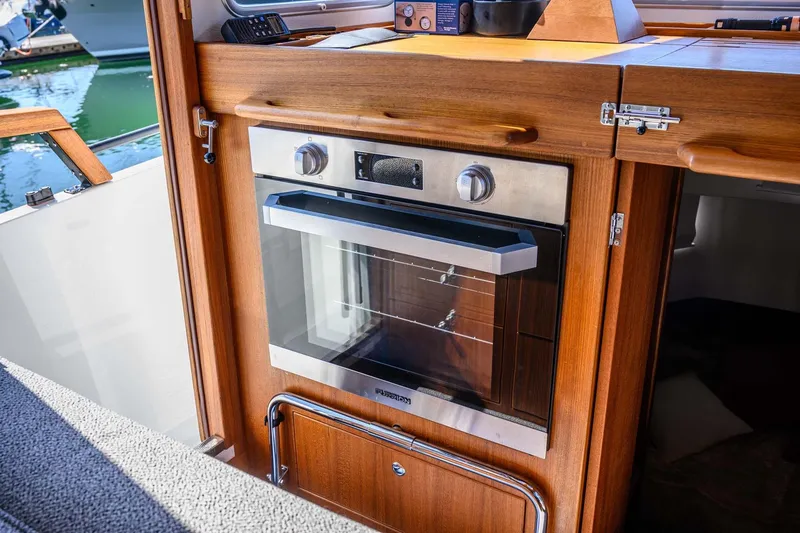 Slide: The Image of Modern kitchen oven in 2024 Targa 37 boat interior, featuring wooden cabinetry. - 17