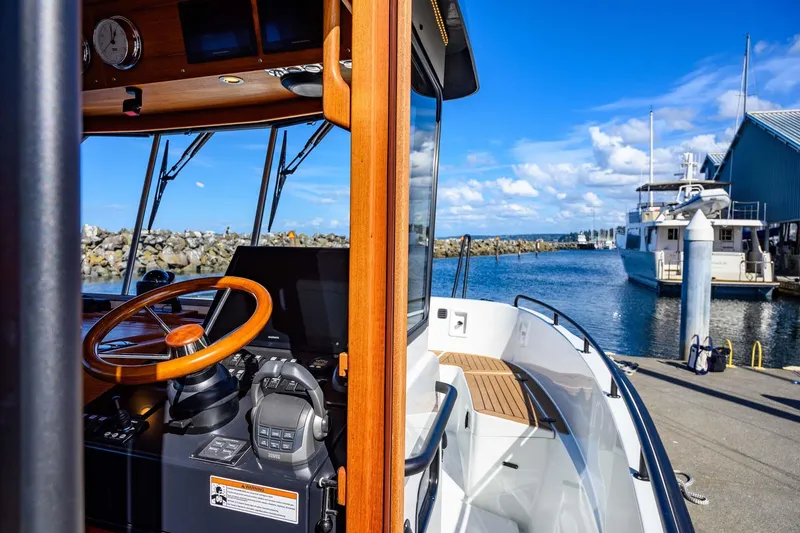 Slide: The Image of 2024 Targa 37 boat cockpit with wooden steering wheel, docked at marina under blue sky. - 19