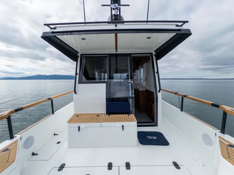Slide: The Image of 2024 Targa 37 boat deck with wooden accents, calm sea background. - 22